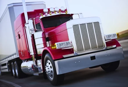 Generic semi truck hauling cargo down the road with motion blur.