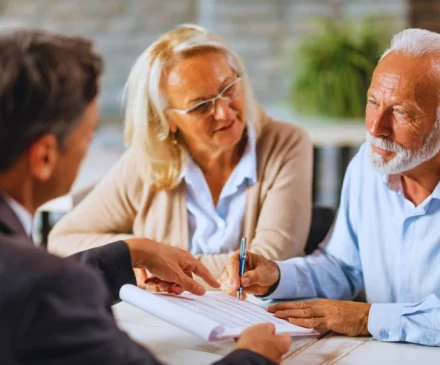 Mature couple having a meeting with bank manager and signing lease agreement in the office. How do personal injury lawyers get paid